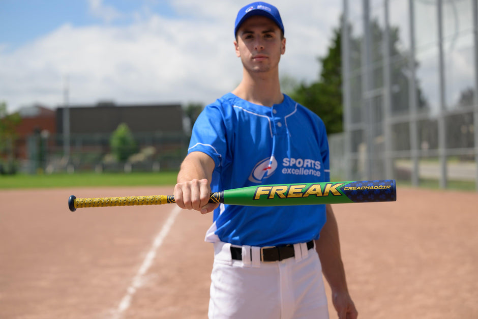 A softball player holding the The Miken Freak CREACHADOIR Slowpitch Bat