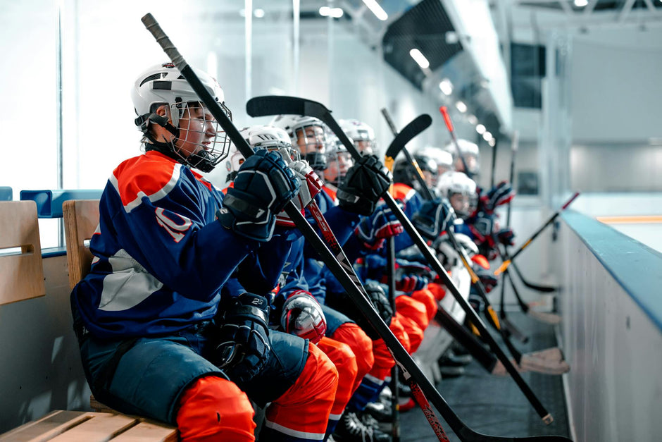 Hockey players holding their hockey sticks, wearing clearance hockey equipment, hockey skates and protective gear