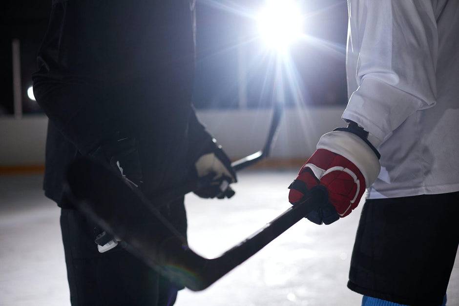 Two hockey players holding their hockey sticks at their local outdoor hockey rink