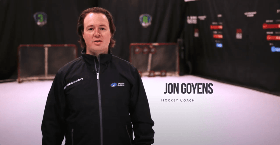 Hockey coach Jon Goyens in his hockey training gym standing in front of two hockey nets